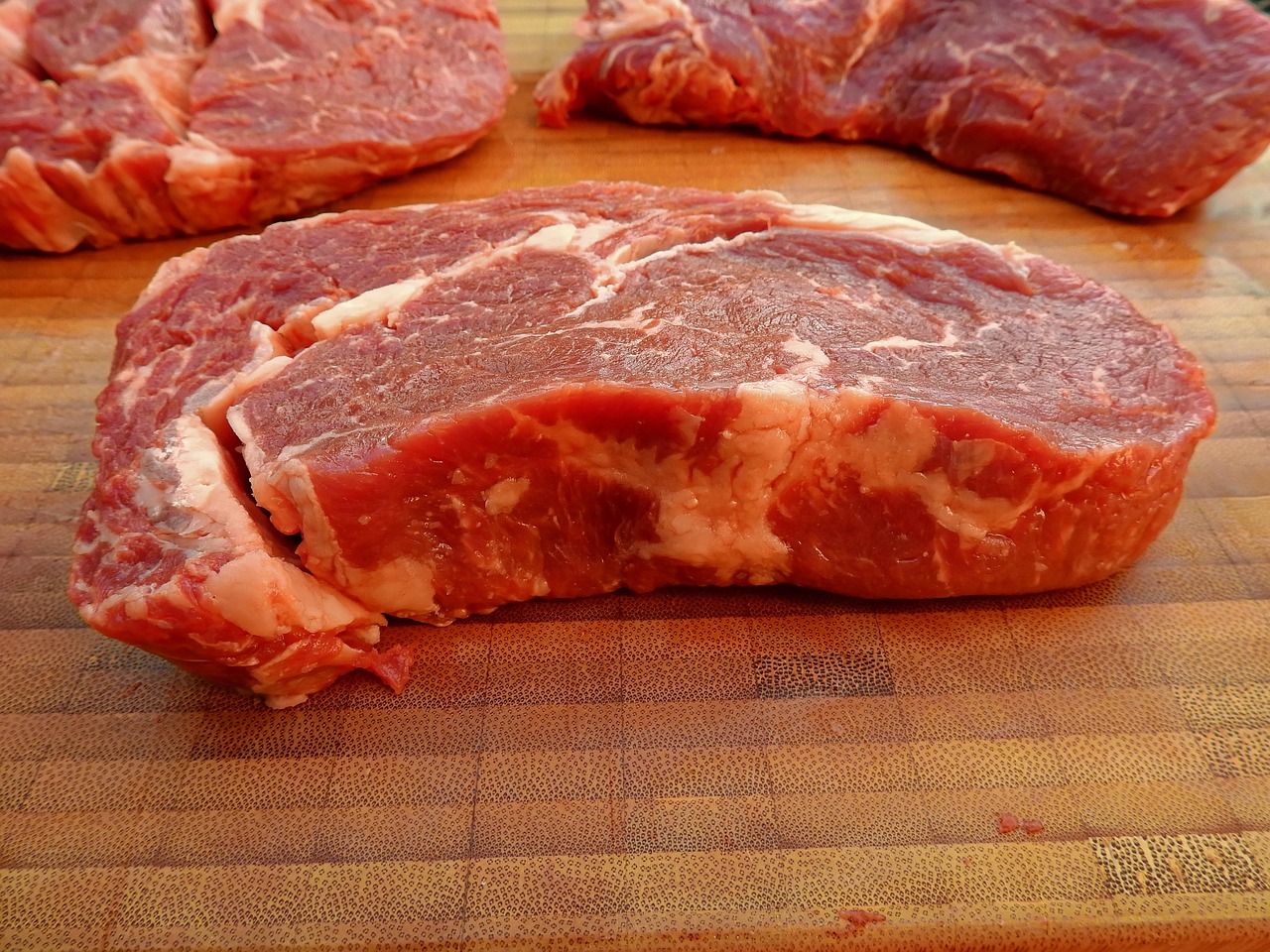 Peças de carne bovina crua sobre tábua de madeira